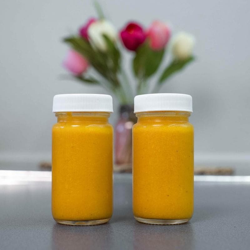 Two ginger shots on a counter.